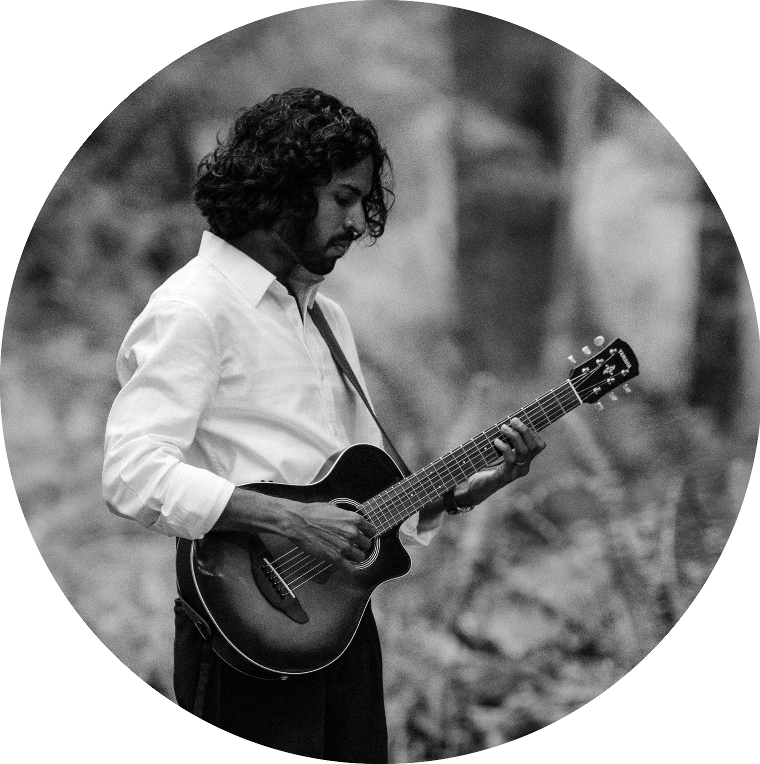Afzal Iqbal playing acoustic guitar outdoors